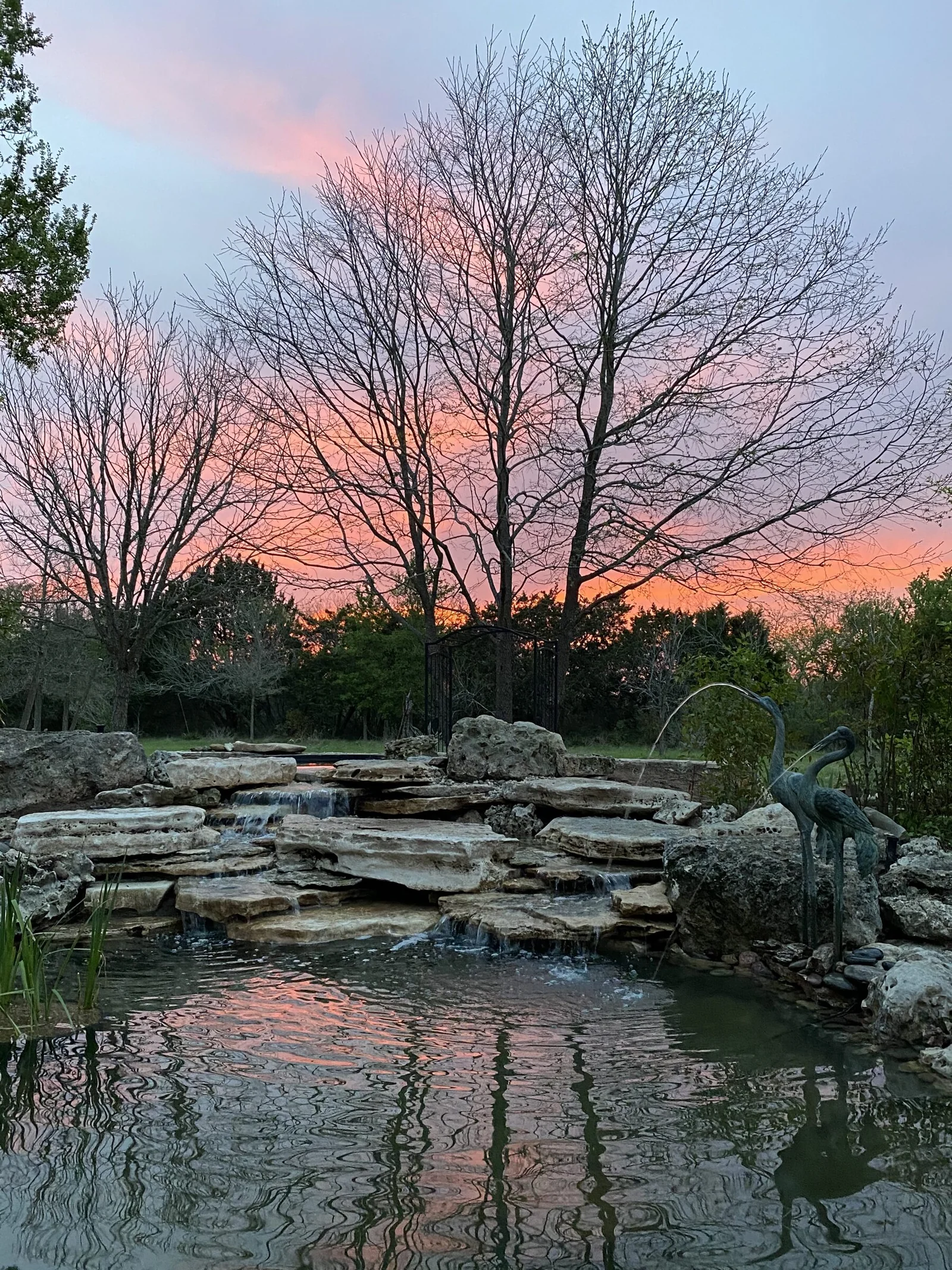Layered limestone waterfall beneath a pink sunset
