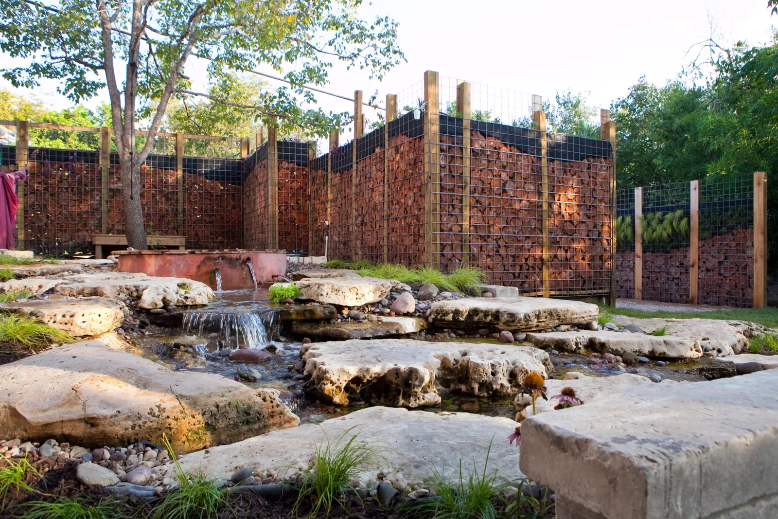 Limestone cascades flowing beneath a garden fence